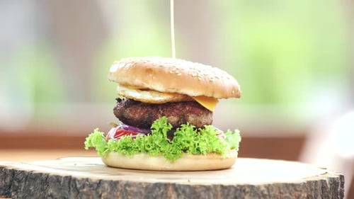 Rotating Burger on Wooden Surface Close Up