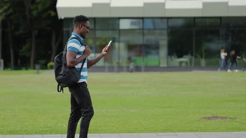 Happy African Man Talking Video Call with Friend Online on the Mobile Phone in the Urban Street