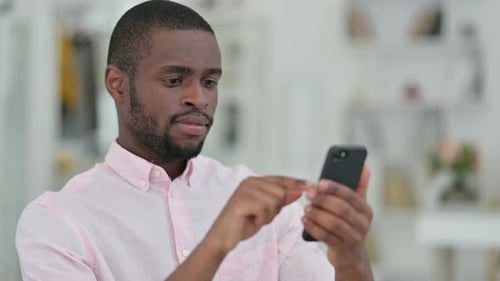 Young Man Using Mobile Phone Indoors