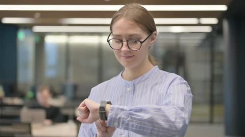 Woman Uses Smartwatch in Bright Modern Office