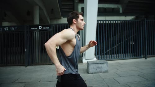 Close Up Male Runner Jogging on Outdoor Workout. Side View of Running Man.