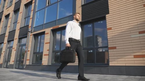 Successful Businessman with Briefcase Walking Near Modern Office Building