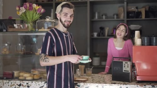 Young Man Receives Coffee at a Cafe Counter