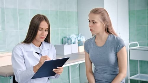 Doctor Discusses Patient Notes in Medical Office