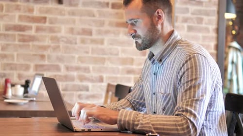 Bart Lässiger Mann arbeitet am Laptop im Loft Place