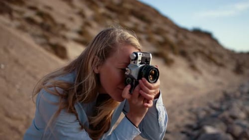 Fotógrafo com foco na câmera Slr na praia