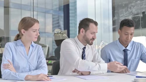 Middle Aged Businessman Explaining on Documents to His Assistants in Office