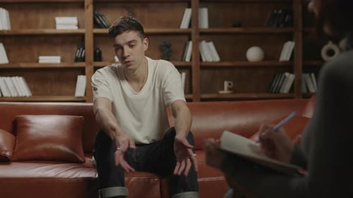 Young Man Talking With Therapist Indoors