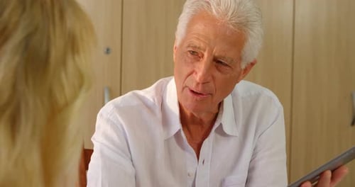 Senior Man Conversing with Tablet Indoors