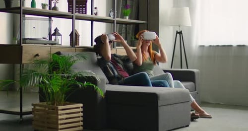 Couple Enjoys Virtual Reality Headsets on Living Room Couch