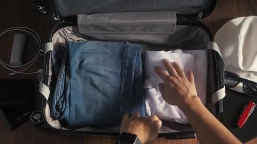 A Man and a Woman Packing a Suitcase or Luggage for Travel. Concept