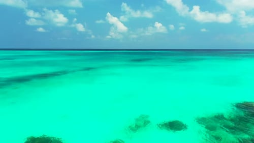 Weitwinkel-Vogelperspektive sauberer Blick auf einen weißen Sandstrand und einen aquablauen Ozeanhintergrund in 4K