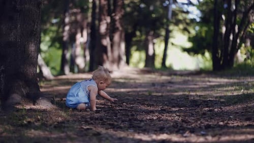 child in the forest. waves his hands and falls on the ass