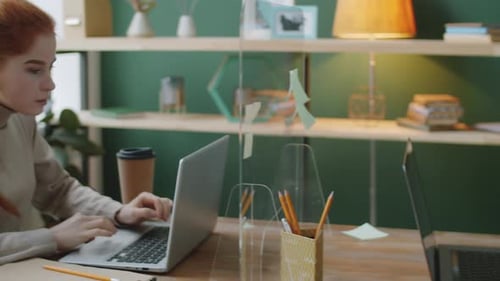 Collègues travaillant à une table de bureau avec barrière en verre