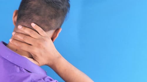Man Suffering From Neck Pain Isolated on Blue