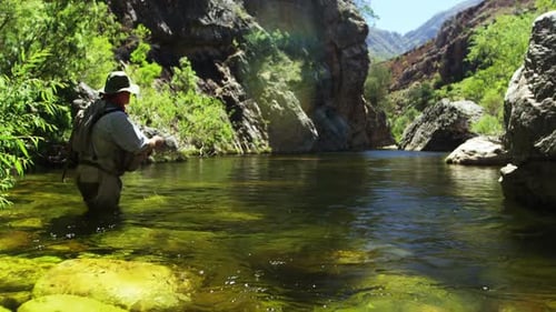 Fisherman fly fishing in river