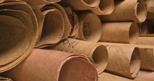 Scrolls with futhpak symbols stacked on pile. Ancient scribe library.