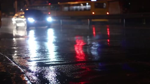 Cars Driving on Wet City Road at Night