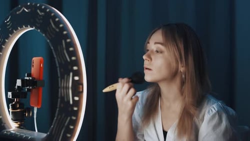Shooting of Attractive Female Beauty Blogger Doing Her Eyes Next to Ring Light