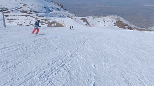 Skiers Descend Snowy Mountain Slopes in Winter