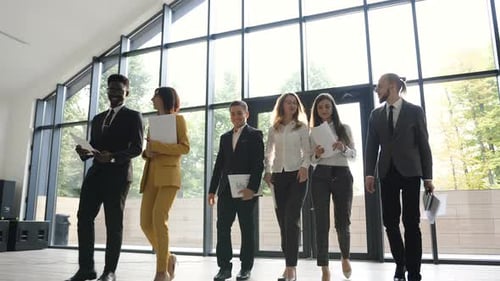 Smiling Colleagues Walk Through Modern Office Building