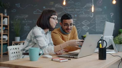 Mixed Race Business Team Man and Woman Talking in Office Looking at Laptop Screen