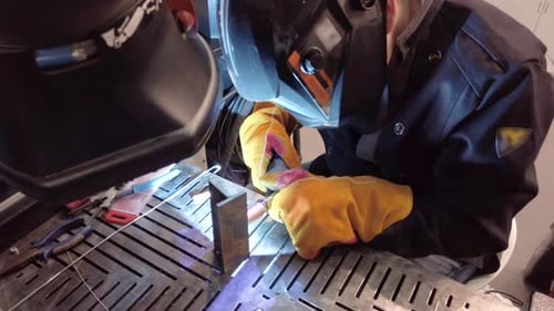 Der Schweißer schweißt Metallteile. Arbeitsplatz des Schweißers