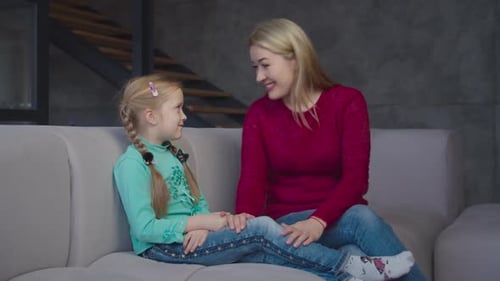 Woman and Child Smiling on Couch Together