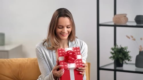 Woman Holds a Gift in Bright Indoor Setting