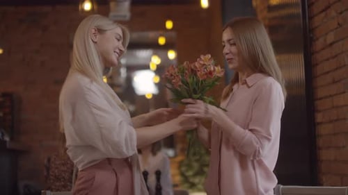 Sequence of Happy Woman Meeting Mother in Cafe and Gifting her Flowers