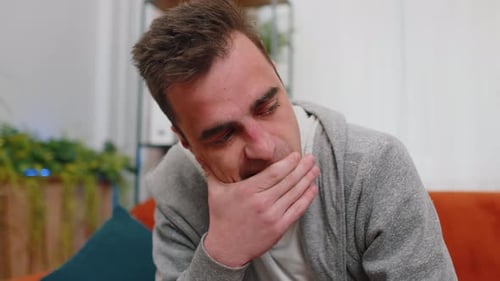 Sad Young Man Crying on the Sofa