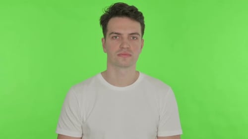 Thumbs Down By Young Man on Green Background