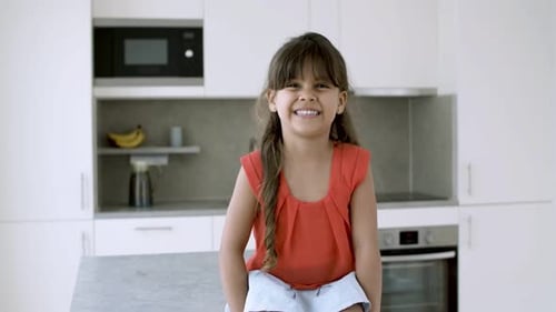 Happy Young Girl Smiling in a White Kitchen