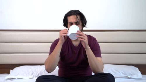 Happy Indian man sipping coffee