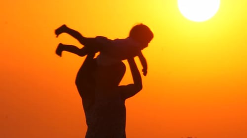 Madre juega con su hija en la playa durante el atardecer. Concepto de paternidad feliz. Antecedentes abstractos