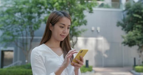 Woman Using Mobile Phone Outdoors in the City