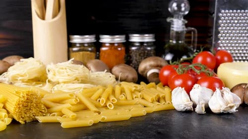 Uncooked Raw Pasta in Different Variety Next To Other Fresh Ingredients