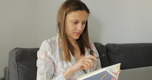 Woman Works From Home With Laptop and Notebook