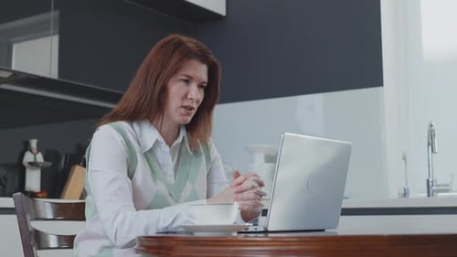 Woman on Laptop Video Call in Kitchen