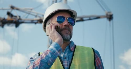 Ingeniero coordinando por teléfono en el sitio de construcción