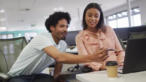 Coworkers Collaborating in Modern Office on Laptop