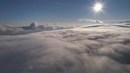 Aerial View Above Dense Cloudscape Under Bright Sun