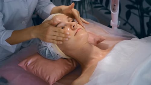 Woman Receiving a Facial Massage at the Spa