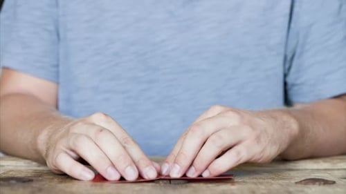 Hands Folding Red Paper Into Origami Heart
