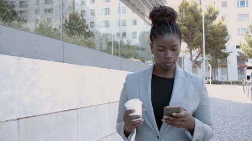 Business Woman Walking with Coffee Using Phone