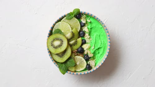 Green Smoothie or Yogurt Bowl. With Fresh Kiwi, Blueberries, Lime and Almond Flakes