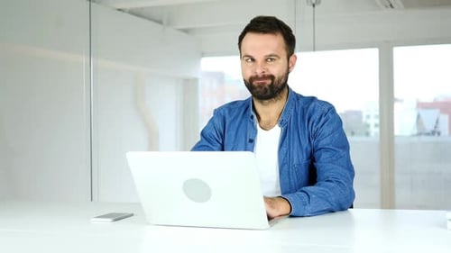 Man Uses Laptop and Makes Silly Face