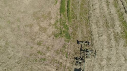 Trator com Rake Tedders no campo da fazenda.