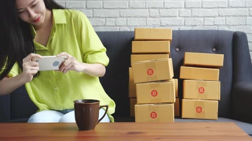 Woman Takes Photo of Boxes with Smartphone
