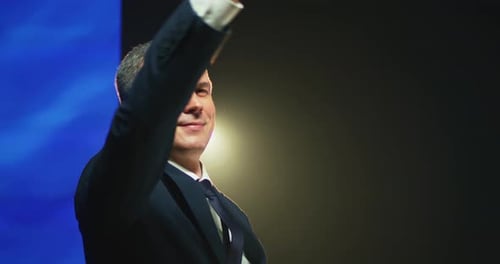 Smiling Man Raises Arms in Front of EU Flag